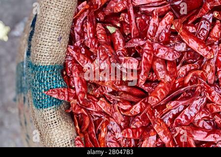 Peperoni rossi in una borsa di tela in un mercato di strada in India Foto Stock