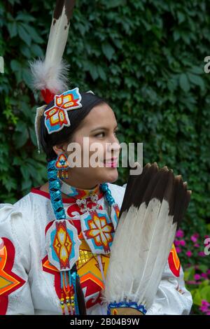 Giovane Salish donna (versione modello 20140213) in un abito jingle con un fan di piume d'aquila al Flathead Lake Lodge di Averill, un ranch dude vicino Kalispell, Foto Stock