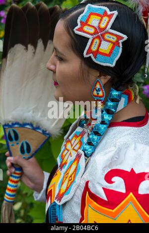 Ritratto di una giovane donna Salish (Model Release 20140213) in abito jingle con un fan di piume d'aquila al Flathead Lake Lodge di Averill, un dude ranch n Foto Stock