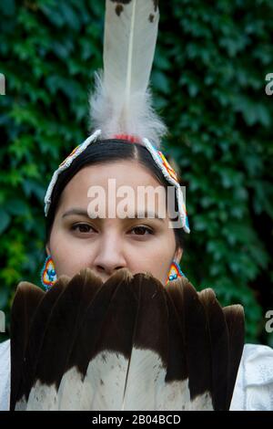 Ritratto di una giovane donna Salish (Model Release 20140213) in abito jingle con un fan di piume d'aquila al Flathead Lake Lodge di Averill, un dude ranch n Foto Stock