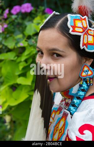 Ritratto di una giovane donna Salish (Model Release 20140213) in abito jingle con un fan di piume d'aquila al Flathead Lake Lodge di Averill, un dude ranch n Foto Stock