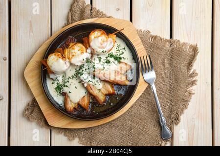 Vista dall'alto di frittelle sottili su spiedini farciti con formaggio e serviti con pancetta fritta Foto Stock