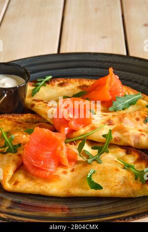 Vista ravvicinata di frittelle sottili con salmone e panna acida Foto Stock