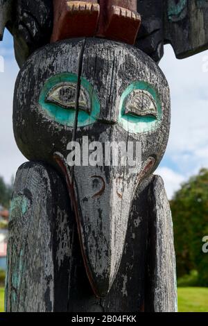 Dettaglio di corvo su un palo Tlingit totem di fronte all'ufficio postale nella città di Wrangell sull'isola di Wrangell, Foresta Nazionale di Tongass, Alaska sudorientale, Stati Uniti. Foto Stock