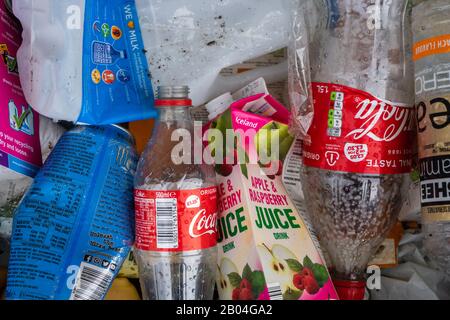 Rifiuti o rifiuti con bottiglie di plastica e cartoni di cartone in un contenitore di riciclaggio Foto Stock