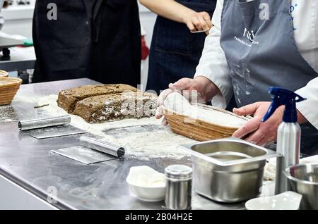 il panettiere insegnante insegna a preparare pane fatto in casa secondo la ricetta Foto Stock