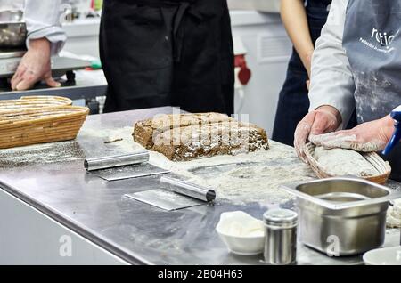 il panettiere insegnante insegna a preparare pane fatto in casa secondo la ricetta Foto Stock