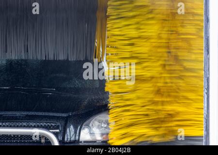 L'auto viene lavata in un tunnel di lavaggio automatico Foto Stock