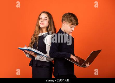 Creare il futuro. I bambini piccoli lo usano il libro ed il calcolatore. Piccola ragazza e ragazzo studiano a scuola. Formazione online. Educare la generazione futura. Oggi bambini, domani tomorrows. Il futuro è ora. Foto Stock