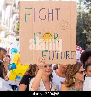 La giovane mamma protesta contro il cambiamento climatico mostrando un segno con un messaggio. Foto Stock