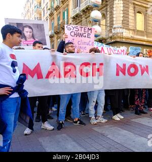 Una processione composta da molti giovani studenti che protestano contro il cambiamento climatico presentando cartelli e striscioni con messaggi. Foto Stock