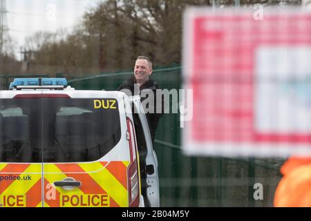 Harefield, Regno Unito. 18 Febbraio 2020. L'ex ciclista paralimpico parzialmente avvistato James Brown of Extinction Rebellion sorride da un veicolo metropolitano di polizia a seguito del suo arresto in un sito HS2 nella Valle di Colne. È stato arrestato dopo essersi bloccato con un altro attivista su un carro di perforazione che gli attivisti ambientali ritengono possa essere utilizzato per perforare la falda acquifera che fornisce il 22% dell’acqua potabile di Londra, rischiando la contaminazione. Credit: Mark Kerrison/Alamy Live News Foto Stock