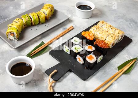 Vari tipi di sushi servita su sfondo di calcestruzzo. Foto Stock