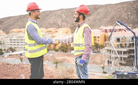 Costruttori di edifici residenziali che fanno un affare - lavoratori Felici sono soddisfatti del loro piano - Negoziazione, immobiliare, ingegnere, industriale e b Foto Stock