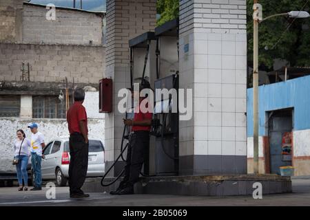 Caracas, Venezuela. 18th Feb, 2020. I dipendenti attendono i prossimi clienti presso una stazione di rifornimento. Credito: Boris Vergara/Dpa/Alamy Live News Foto Stock