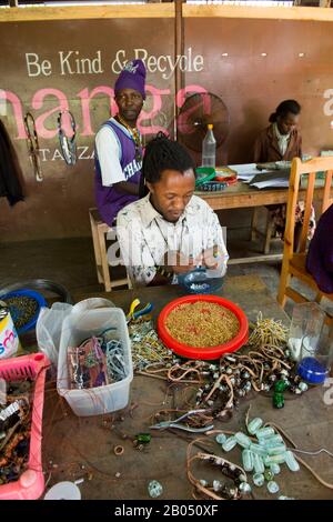 Persone disabili locali che fanno artigianato utilizzando materiali riciclati per il mercato all'ingrosso e al dettaglio dei consumatori presso la Shanga House di Arusha, in Tanzania Foto Stock