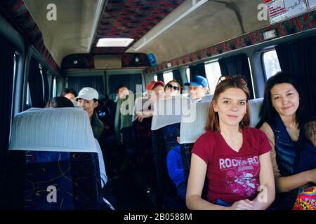 Bishkek, Kyrgyzstan - 9 aprile 2019: Giornata internazionale della catena. I turisti vanno in montagna per un'escursione. Persone sull'autobus Foto Stock