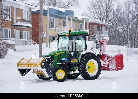 Trattore spazzaneve che sgombrano la neve di fronte a una casa, Laval, provincia di Quebec, Canada. Foto Stock