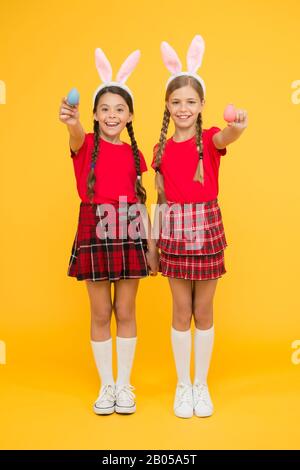 per voi. inizia la caccia alle uova. vacanza primaverile tradizionale. buona pasqua. la primavera è in arrivo. concetto di infanzia felice. ragazze piccole bunny spighe sfondo giallo. bambini simpatici sorella piccola celebrare pasqua. Foto Stock