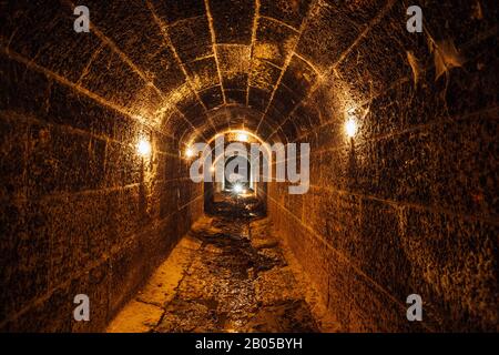 Scuro e creepy vecchio storico a volta allagato tunnel sotterraneo di drenaggio Foto Stock