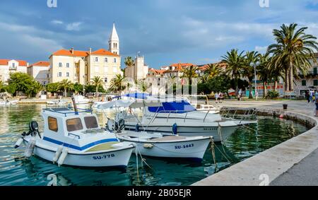 Supetar, Croazia - 22 maggio 2019: Città di Supetar sull'isola di Brac vicino Spalato, Croazia. Bellissimo porto con barche bianche, palme, case e la chiesa di rimorchio Foto Stock