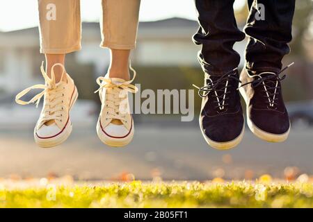 Primo piano dei piedi della coppia che saltano sul sentiero. Foto Stock