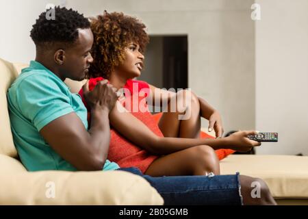 Black African American coppia guardare la tv nel soggiorno Foto Stock