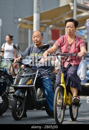 Persone cinesi su scooter e biciclette nella città vecchia di Shanghai, Penglai Road, Huangpu. Cina Foto Stock