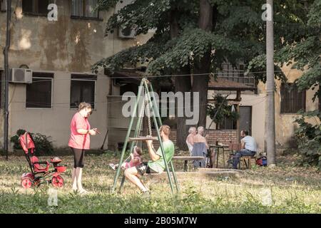 Belgrado, SERBIA - 2 AGOSTO 2015: Serbianamily, madre, padre e figlia, gioca a swing nel parco giochi per bambini di Staro Sa Foto Stock