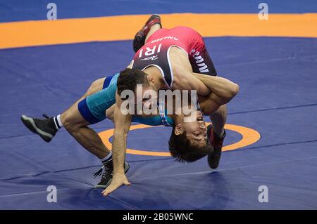 New Delhi, India. 18th Feb, 2020. Pouya Mohammad Naserpour of Iran (top) vies con Jasurbek Ortikboev di Uzbekistan durante la 55kg partita finale di lotta Greco-Romana degli uomini ai Campionati asiatici di Wrestling 2020 a Nuova Delhi, India, 18 febbraio 2020. Credit: Javed Dar/Xinhua/Alamy Live News Foto Stock