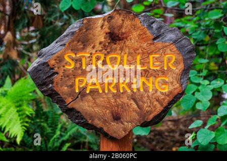 Stroller Parking Sign for Babys and Family on Wood Sign with Foliage and Leaves in background Foto Stock