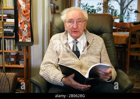 Rostock, Germania. 12th Feb, 2020. Hartwig Eschenburg, musicista della chiesa, è seduto in una poltrona nel suo appartamento con un libro. Il musicista della chiesa riceverà il Premio sociale Siemerling della Neubrandenburg Epiphany Foundation il 24 febbraio 2020. Il premio è dotato di 10.000 euro ed è considerato il più antico premio sociale del nord-est. Credito: Bernd Wüstneck/Dpa-Zentralbild/Dpa/Alamy Live News Foto Stock