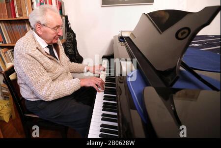 Rostock, Germania. 12th Feb, 2020. Hartwig Eschenburg, musicista di chiesa, suona su un pianoforte nel suo appartamento. Il musicista della chiesa riceverà il Premio sociale Siemerling della Neubrandenburg Epiphany Foundation il 24 febbraio 2020. Il premio è dotato di 10.000 euro ed è considerato il più antico premio sociale del nord-est. Credito: Bernd Wüstneck/Dpa-Zentralbild/Dpa/Alamy Live News Foto Stock