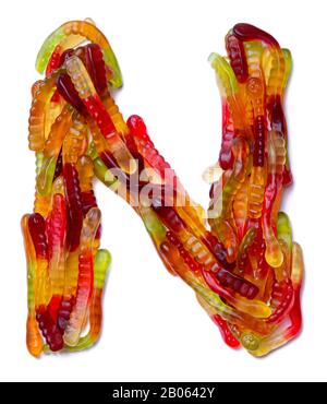 Lettera N dell'alfabeto inglese da una marmellata da masticare multicolore su sfondo bianco isolato. Modello di cibo fatto ffrom i dolci dei bambini serpente Foto Stock