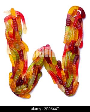 Lettera W dell'alfabeto inglese da una marmellata da masticare multicolore su sfondo bianco isolato. Modello di cibo fatto ffrom i dolci dei bambini serpente Foto Stock