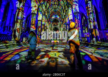 Gli uscieri ammirano l'interno della Cattedrale di Salisbury, dove un'installazione di arte leggera e sonora, chiamata Sarum Lights, segna il 800th anniversario della Cattedrale nel 2020, illuminando l'interno e l'esterno insieme alla musica. Foto Stock