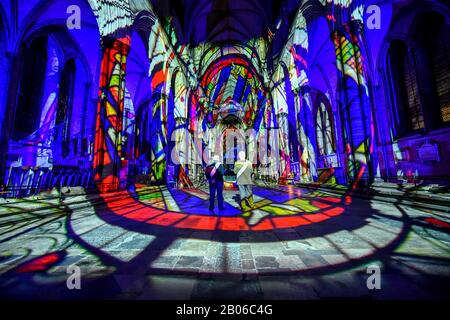 Gli uscieri ammirano l'interno della Cattedrale di Salisbury, dove un'installazione di arte leggera e sonora, chiamata Sarum Lights, segna il 800th anniversario della Cattedrale nel 2020, illuminando l'interno e l'esterno insieme alla musica. Foto Stock