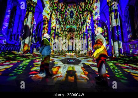 Gli uscieri ammirano l'interno della Cattedrale di Salisbury, dove un'installazione di arte leggera e sonora, chiamata Sarum Lights, segna il 800th anniversario della Cattedrale nel 2020, illuminando l'interno e l'esterno insieme alla musica. Foto Stock