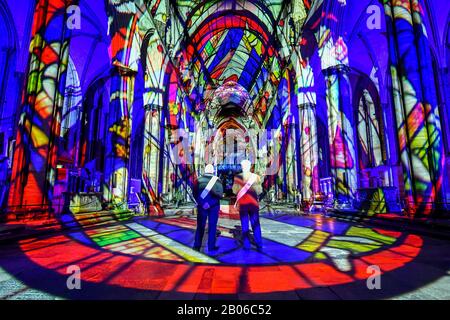 Gli uscieri ammirano l'interno della Cattedrale di Salisbury, dove un'installazione di arte leggera e sonora, chiamata Sarum Lights, segna il 800th anniversario della Cattedrale nel 2020, illuminando l'interno e l'esterno insieme alla musica. Foto Stock