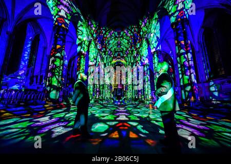 Gli uscieri ammirano l'interno della Cattedrale di Salisbury, dove un'installazione di arte leggera e sonora, chiamata Sarum Lights, segna il 800th anniversario della Cattedrale nel 2020, illuminando l'interno e l'esterno insieme alla musica. Foto Stock