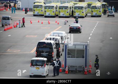 Yokohama, Giappone. 19th Feb 2020. I veicoli entrano nel porto di Yokohama in Giappone, 19 febbraio 2020, dove la 'Principessa del Diamond', una nave da crociera, è stata tenuta in quarantena. I passeggeri della nave da crociera Diamond Princess inflitta al nuovo coronavirus hanno iniziato a sbarcare mercoledì nel porto giapponese di Yokohama dopo un periodo di quarantena di due settimane. In almeno tre giorni, quasi 3.000 persone sbarcheranno dalla nave che ha confermato 542 casi del virus che causa la polmonite finora, secondo il governo. Credito: Xinhua/Alamy Live News Foto Stock