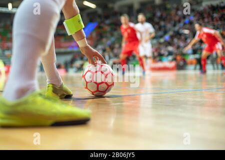 Partita Futsal - primo piano di palla in angolo e mano e gambe del giocatore. Foto Stock