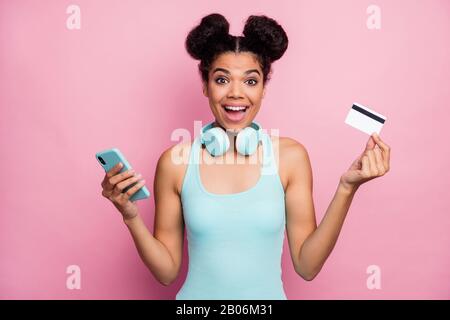 Primo piano ritratto di lei bella bella bella bella bella carino allegro allegro cheery ragazza con capelli ondulati utilizzando carta bancaria acquisto brano hit isolato Foto Stock