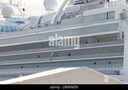 Yokohama, Giappone. 19th Feb 2020. I passeggeri sono visti sui balconi delle loro camere sulla 'Principessa del Diamond', una nave da crociera che è stata tenuta in quarantena al porto di Yokohama in Giappone, 19 febbraio 2020. I passeggeri della nave da crociera Diamond Princess inflitta al nuovo coronavirus hanno iniziato a sbarcare mercoledì nel porto giapponese di Yokohama dopo un periodo di quarantena di due settimane. In almeno tre giorni, quasi 3.000 persone sbarcheranno dalla nave che ha confermato 542 casi del virus che causa la polmonite finora, secondo il governo. Credito: Xinhua/Alamy Live News Foto Stock