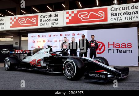 Haas F1 piloti Kevin Magnussen (a sinistra) e Romain Grosjean (a destra) insieme al team principal Guenther Steiner (seconda a destra) e proprietario Gene Haas mentre svelano la nuova vettura per la stagione 2020 F1 durante il giorno uno dei test pre-stagione al Circuit de Barcelona-Catalunya. Foto Stock