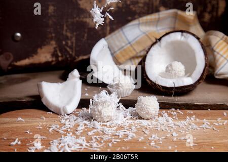 Primo piano di tartufi di cocco cioccolato dolce e cocco con polpa bianca, chip di cocco. Cioccolato bianco cocco dolci e guscio di cocco, cocco flak Foto Stock