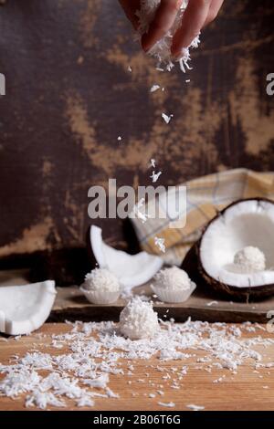 Primo piano di tartufi di cocco cioccolato dolce e cocco con polpa bianca, chip di cocco. Cioccolato bianco cocco dolci e guscio di cocco, cocco flak Foto Stock