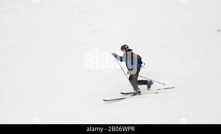 Stazione sciistica. Lo sciatore scende rapidamente su una pista professionale coperta di neve. Neve bianca. Sport professionale. Foto Stock