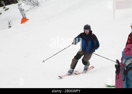 Stazione sciistica. Lo sciatore scende rapidamente su una pista professionale coperta di neve. Neve bianca. Sport professionale. Foto Stock