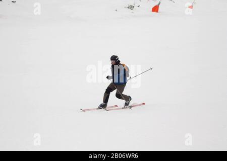 Stazione sciistica. Lo sciatore scende rapidamente su una pista professionale coperta di neve. Neve bianca. Sport professionale. Foto Stock